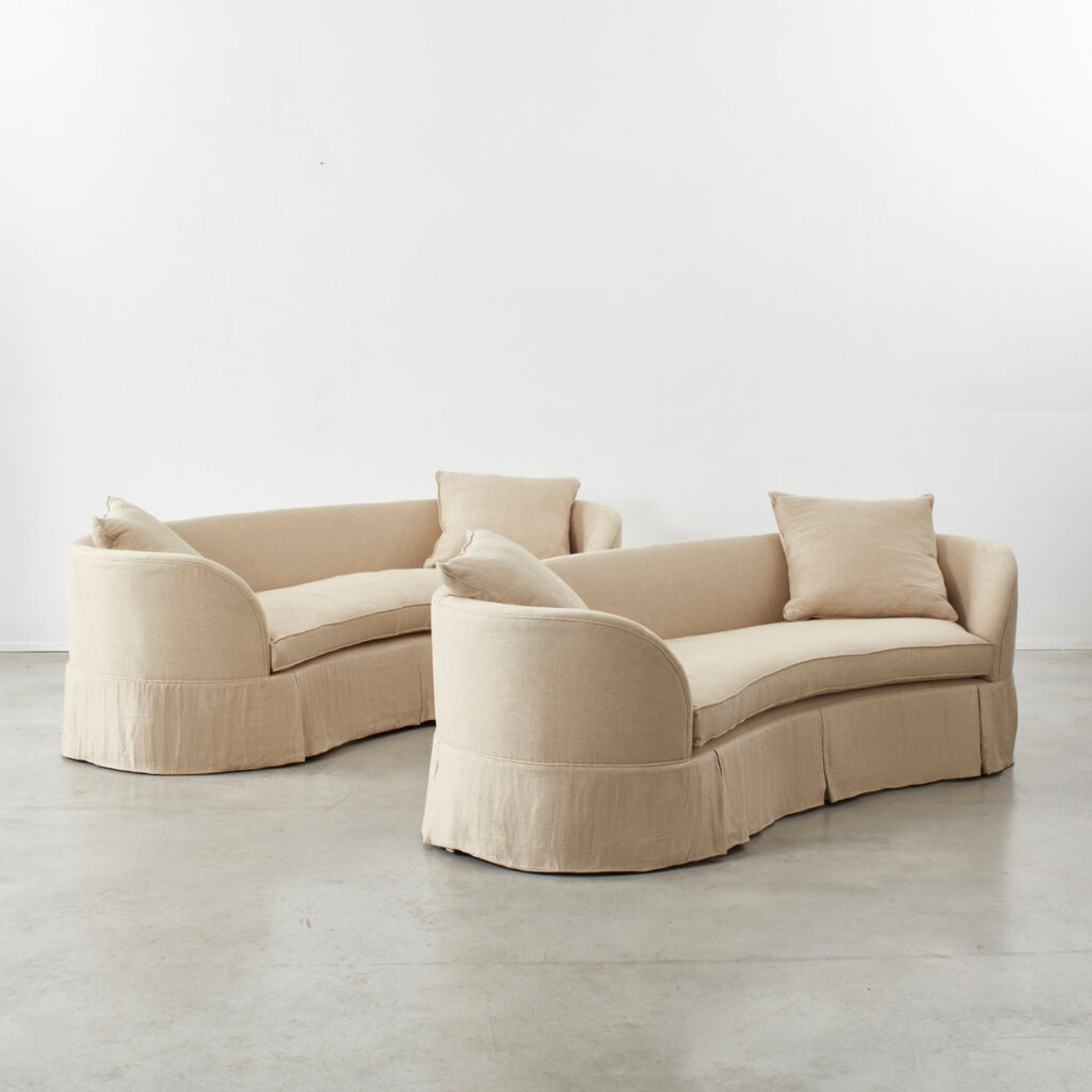 Pair of curved banana skirted sofas