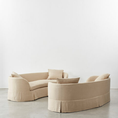 Pair of curved banana skirted sofas